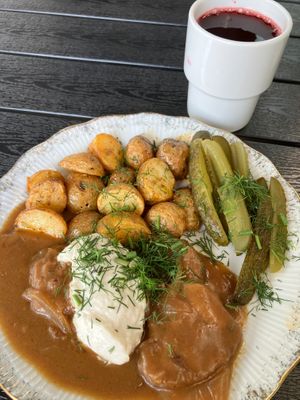 Soy cutlets in sauce (front), homemade compote with fresh fruit (back) at Vegan Friends Kitchen in Warsaw