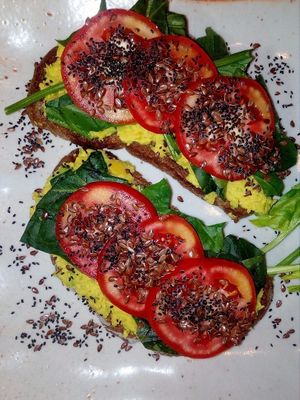 Avocado sandwiches with spinach , tomatoes and chia seeds on the rye bread at Bamboo Bar & Vegetarian Restaurant in Sihanoukville