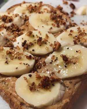 PB Crunch, handmade sourdough toast, peanut butter, banana, house made quinoa brittle, cocoa nibs.   at Nourish Wellness Cafe - Pop Life  in Cleveland