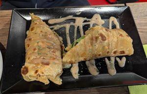 "Rolex" roll, a flat bread with lots of filling rolled up and grilled with peanut sauce on top at Shani's African Snacks in Hamburg