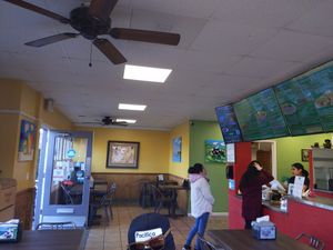Inside the dining area. You can see the menu takes up fully two large flat screens, plus a smaller acreen and there's a whiteboard for desserts! at El Cantaro Vegan Mexican Restaurant in Monterey