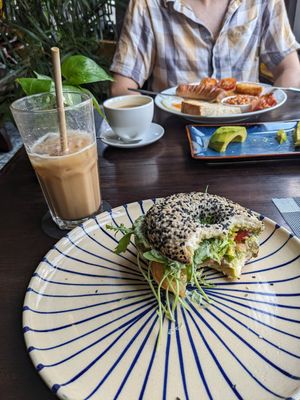 Vegan basil ricotta bagel that I added avocado to and almond milk latte. at Tartine Saigon - District 1 in Ho Chi Minh City