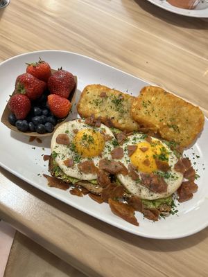 Avocado toast with sunny side up eggs, bacon and hashbrowns.   at A Lo Vegano in Orlando