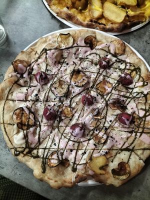 Pizza with pistachio cream, rose cream, courgette chips, hazelnut balls, black salt at Opera 140 - Maybe closed in Genoa