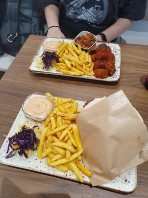 Two plates featuring Just Vege's dishes: Hummus & Falafel Pita with gluten free pita bread; Vegan meatballs with bean salad, both dishes came with fries. at Just Vege - Forum in Helsinki