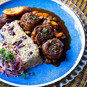  Tender plant-based oxtail slow-cooked till di flavors melt, drenched in rich gravy made from tomatoes, soy sauce, an' Caribbean spices. Served wit' rice, dis is true soul food at Cafe Caye Mange in Yarmouth