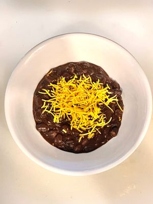 Black beans topped with shred-shed vegan cheese at La Arepa in Portland