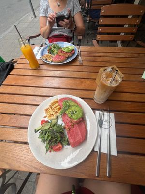 Avocado toast with beet root hummus, iced coffee with oat milk and fresh orange juice at Lara Cafè Budapest  in Budapest