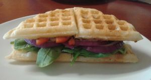 The Big V, piles of veggies, black bean hummus and avocado on a waffle  at The Bald Strawberry Cafe in Indialantic