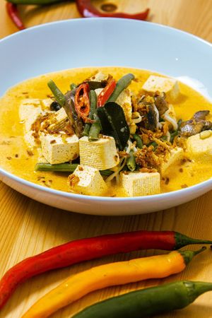 Tofu, green beans and mushrooms in curry with: coconut milk, galangal, ginger, fresh mung bean sprouts, candle-nuts, turmeric, tamarind, lemongrass, shallots, garlic, hot chillies at Taste of Bali in Timisoara