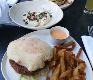 Specialty burger with nuts, fries, nutty sauce and hummus with mint at Samsara in Cluj-napoca