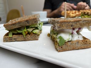 Vegan waffle sandwich with curried chickpeas, avocado, greens, and vegan mayo.  at La Maison Oflore in Montreal