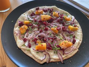 TARTE FLAMBÈ TOPPED WITH PUMPKIN, ONIONS, VEGGIE MEAT, CASHEW SOUR CREAM  at inner you vegan in Tenerife