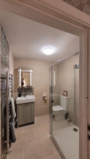 The ensuite shower has a dispenser full of Faith in Nature shampoo, conditioner and body wash. at The Wildflower Retreat Vegan B&B in Tipton St John