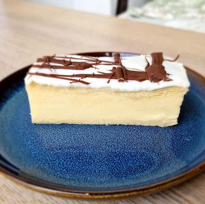  Indulge in the ultimate dessert experience with our Creme Patisserie Slice! Picture this: a dreamy vanilla creme custard sandwiched between two deliciously flaky pastry, topped with a generous layer of icing and finished with our very own chocolate. at Heavenly Vegan Coffi in Barry