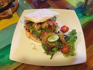 Falafel sandwich with onion rings and salad at Green Point in Cusco
