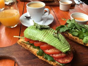 Savoury breakfast: Roasted bread with herbs topped with rucola (arugula), tomato and avocado, served with a tomato sauce on the side and a fresh juice and coffee at Green Point in Cusco