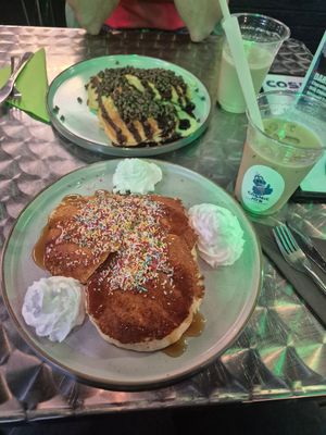 Vegan pancakes with maple sirup, sprinkles and whipped cream (front). Vegetarian pancakes with chocolate sauce and chocolate chips (back). at Cosmic Jo's Galactic Trading Outpost in Norwich
