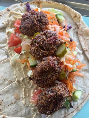 Falafel Wrap served on Lebanese Khobez, with hummus tahini pickles & 
All the salad 💚 Lettuce, red cabbage, grated carrot, cucumber, tomato, red onion. at Veg Fans in Birmingham