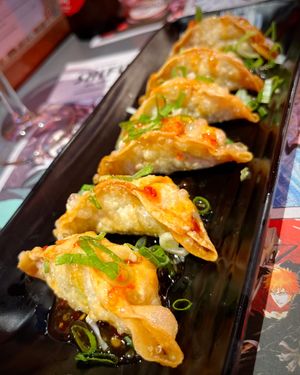 Age gyozas veganas: fried gyozas stuffed with cabbage, onion, carrot and chives, with sweet chili sauce at Ramen Shifu in Oviedo