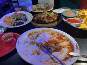 the bean burrito in the foreground went fast! Nice sauce. Rice & black beans far left. refried vegan pinto beans & salsa far right. Fajitas in the middle.  at Rio Mexican Cuisine in Burnsville