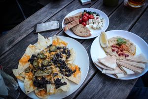 starters - nachos with cheddar cheese and frijole, hummus with pita bread, feta cheese with olives, baked cherry tomatoes and bread at Vegtral Restaurace in Prague