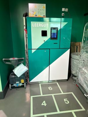 Vor dem Leergut-Automat sind Hüpfkästchen aufgedruckt.  at REWE Voll Pflanzlich in Berlin