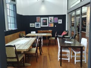 Lovely atmosphere, cosy reclaimed church pews on the left, open to the art gallery on the right. at Awhi Community Cafe in Palmerston North