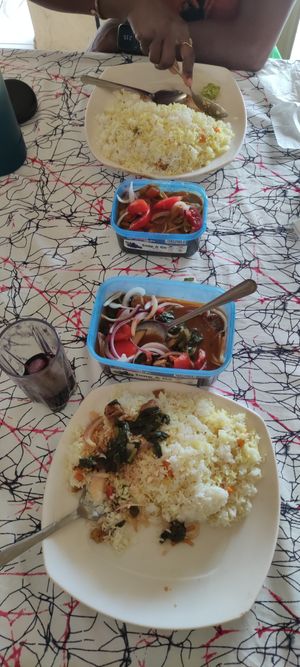 Gboma dessi stew in the foreground, peanut stew (sauce d'arachide) in the background with hibsicus juice.  at Govinda's Veggie Vegan in Lome