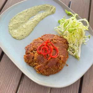 Vegan Crab Cake- large crabless cake filled with hearts of palm, chickpeas, topped with peppers frisee and served with a tomatillo remoulade at Jackson's Bistro in Tampa