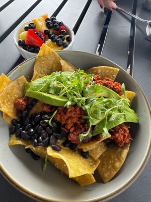 Fresh tortilla chips with black beans, soy chorizo, sliced avocado, fresh fruit on the side Topped with spring mix at Elderwood at the Darling in Visalia