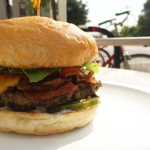Bacon Ranch Cheeseburger with housemade cheese sauce, ranch, grilled onions, tomato, pickles, lettuce. at Liberation Kitchen in Chicago