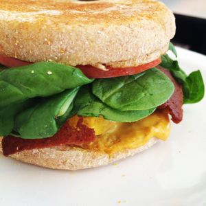 Vegan Breakfast Sandwich with Bacon Seitan, grilled tofu, hollandaise, spinach and tomato on an English muffin. at Liberation Kitchen in Chicago