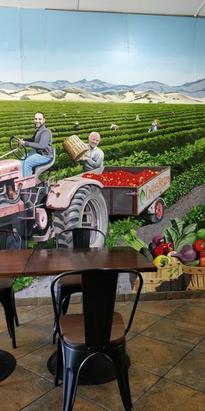 Cute mural inside featuring the owner and his son harvesting tomatoes. at Crepes Bistro in Santa Clara