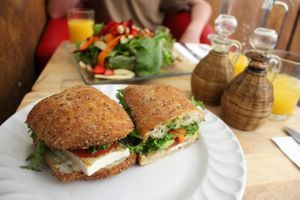 Wholegrain ciabatta with tofu, pesto and salad. In the background is vegan salad with cashews, beets and strawberries. at Xiguela Cafe in Oaxaca