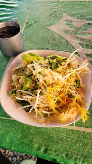 Green curry fried rice with veggies, topped with fresh sprouts, salad, cucumber, and a free cup of iced water at Khanomchin Che Kai - Food Stall in Koh Samui