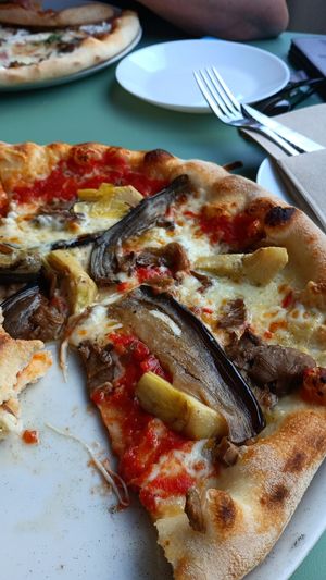 A delicious vegan pizza topped with flavorful artichokes and melted vegan cheese. The artichokes were especially tasty! at Pizzaloriano in San Roque