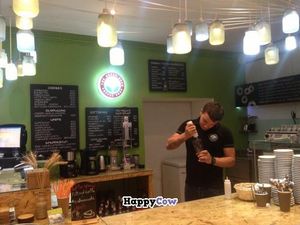 Barista putting some chocolate syrup in my cup at The Green Bean Coffee Shop in Yerevan