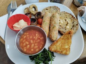 Vegan breakfast : sausages, mushrooms, cherry tomatoes, beans, hash browns, spinach, hummus, sourdough toast. at Bullet Coffee House and Eatery in Hastings