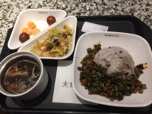 platter contains cabbage salad, seaweed soup fruit, and main dish of rice and carrot/okra/tofu cubes cooked in mild sauce at Yi Tian Yi Su - Taiguhui in Guangzhou