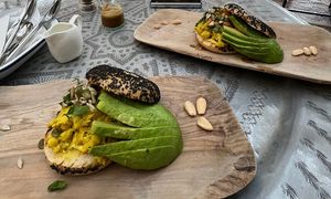 Home made from chickpeas milk, turmeric, spring onions and herbs. Served on a toasted bagel with our home made vegan cheese sauce, tomatoes and avocado  at Comptoir 102 in Dubai