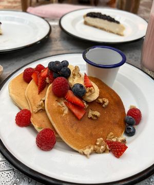 Gluten free vegan pancakes with almond milk, orange zest, orange blossom and maple syrup. Served with fresh bananas, fresh mixed berries and walnuts.  at Comptoir 102 in Dubai