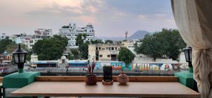 Lakeside views with bar tables along the railing. at Smokey Jo's Cafe in Udaipur