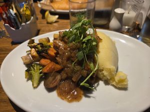 Saucisses purée, sauce gravy et légumes rôtis at Roam West in Fort William