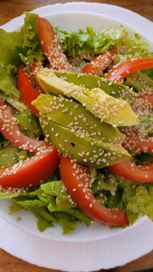 Appetiser salad contains avocado, tomato and lettuce with sesame seeds and a light dressing at Amaranta Cocina Consciente in Medellin