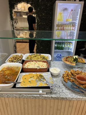 Hot food options inc pizza with lemonade in the fridge behind.  at Verde Hut in Porto