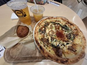 Vegan Teriyaki Soy Meat Pizza and Vegan Freshly Fried Curry bread with pint of Kirin and orange juice. 👏 at HND - Chaya Vegan Friendly Tokyo - T3 in Ota