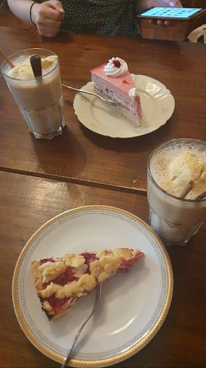 Iced latte (with vanilla ice), a raspberry cream cake and one with red berries and crumble on top at V-Cake Cafe in Dresden