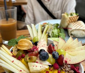 Golden porridge with berries and fresh fruit. Chikken (vegan) wrap in the background.  at V-Cake Cafe in Dresden