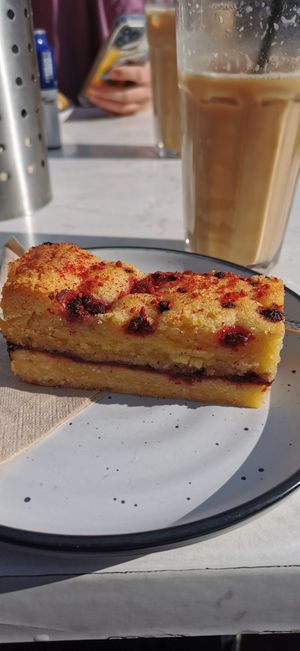 Frangipan slice and iced vanilla latte in the background at Alimento Eatery in Tauranga